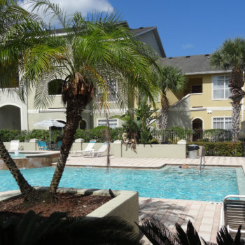 The pool area is beautifully landscaped with mature, tropical foliage.